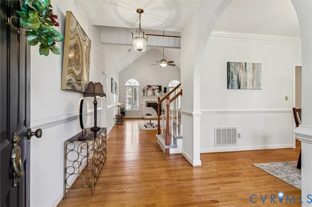 a view of a hallway with wooden floor and staircase