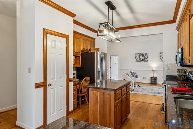 a kitchen with stainless steel appliances granite countertop a refrigerator a stove and a sink