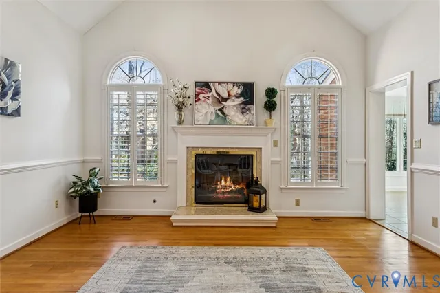 a view of an empty room with a fireplace and wooden floor