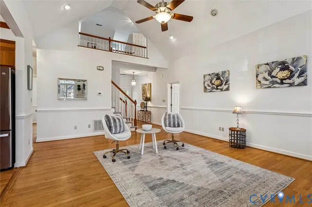 a room with lots of white furniture and wooden floor