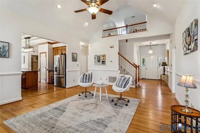 a living room with lots of furniture wooden floor and a chandelier