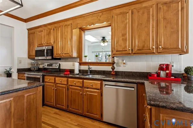 a kitchen with stainless steel appliances granite countertop a sink stove and cabinets