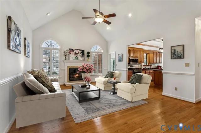 a living room with furniture a fireplace and a chandelier