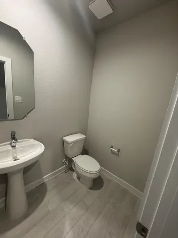 a bathroom with a toilet a sink and mirror