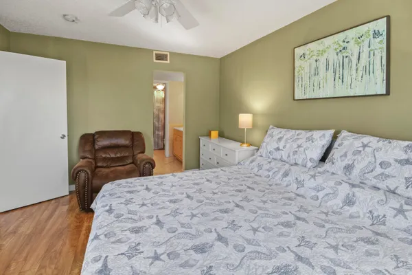 a bedroom with a bed and a painting on the wall