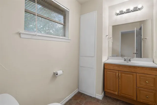 a bathroom with a sink and mirror with toilet