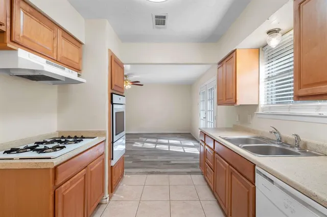a kitchen with granite countertop a sink stove and cabinets