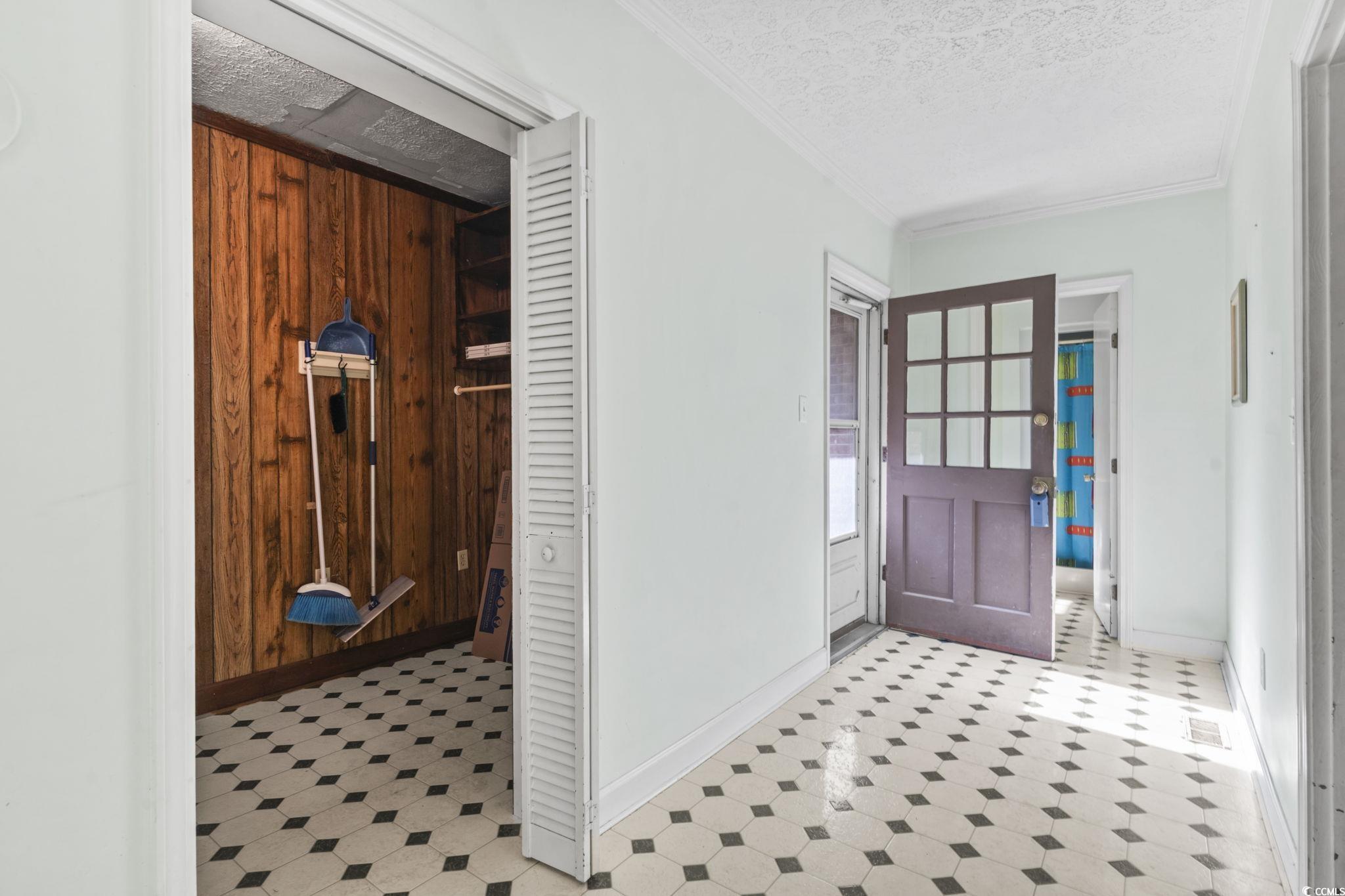 6971 Alfred Road Aynor, SC 29511 - Photo 17 of 37 Foyer entrance with light flooring, crown molding, a textured ceiling, and wooden walls