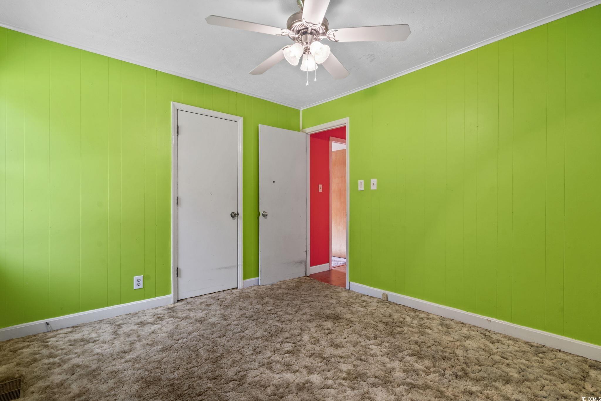 6971 Alfred Road Aynor, SC 29511 - Photo 21 of 37 Unfurnished bedroom with wooden walls, carpet floors, crown molding, and ceiling fan