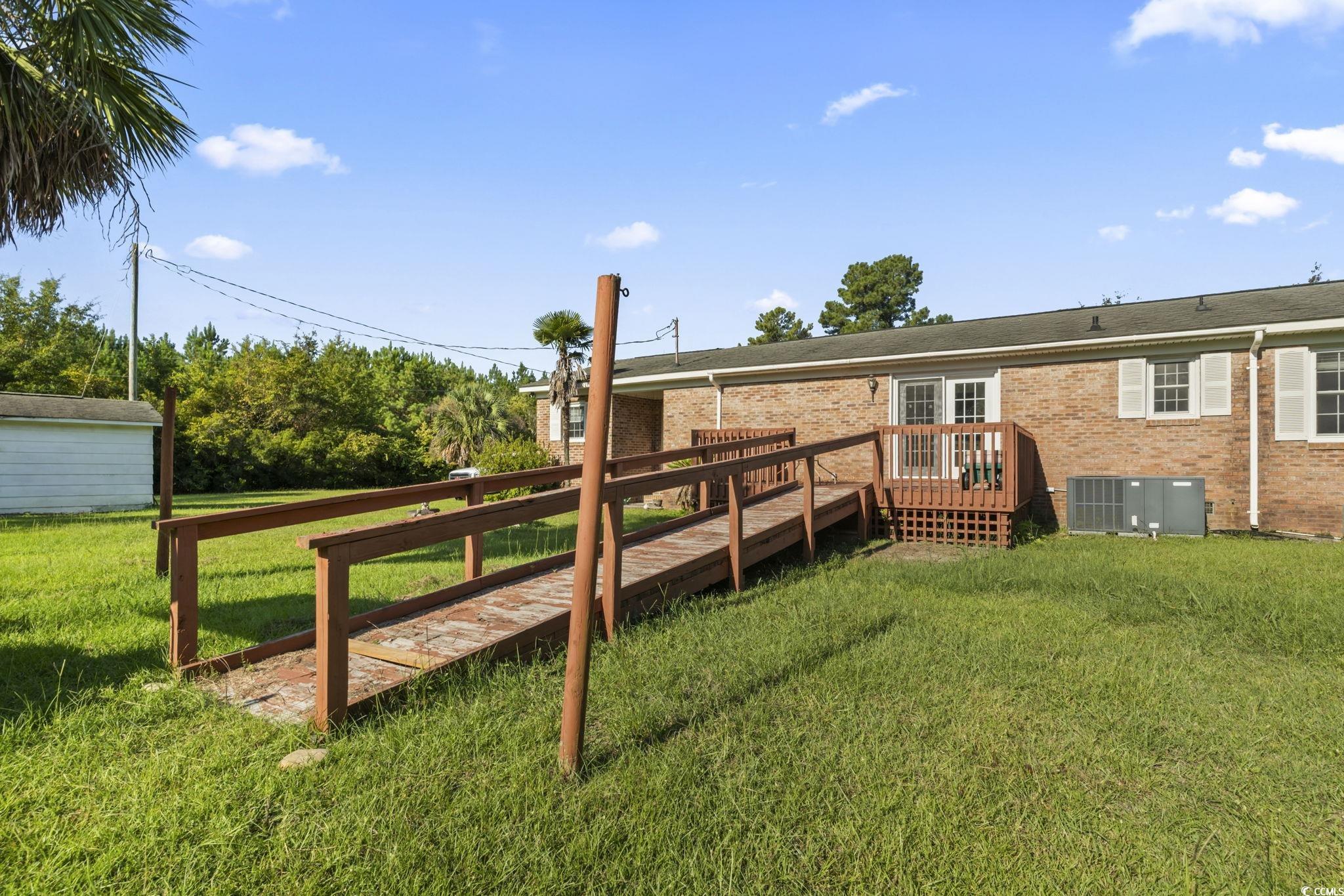 6971 Alfred Road Aynor, SC 29511 - Photo 32 of 37 Rear view of house with a lawn, a deck, and brick siding