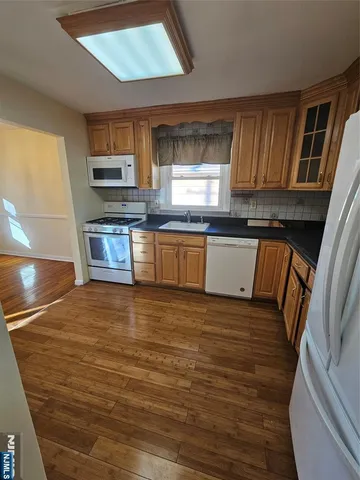 a kitchen with stainless steel appliances granite countertop a sink dishwasher stove and microwave