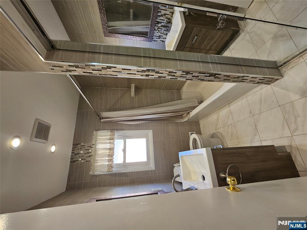 122 Eckel Road Little Ferry, NJ 07643 - Photo 8 of 16 a bathroom with a sink a toilet and shower