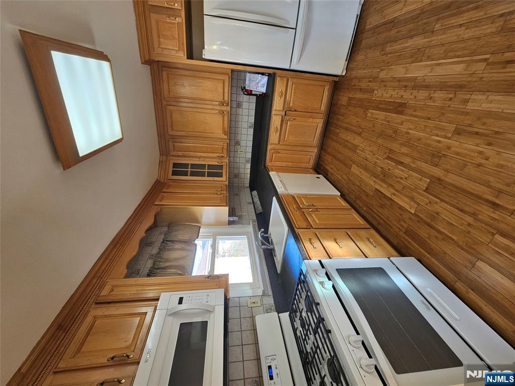 122 Eckel Road Little Ferry, NJ 07643 - Photo 9 of 16 a kitchen with granite countertop wooden floors a stove and a microwave