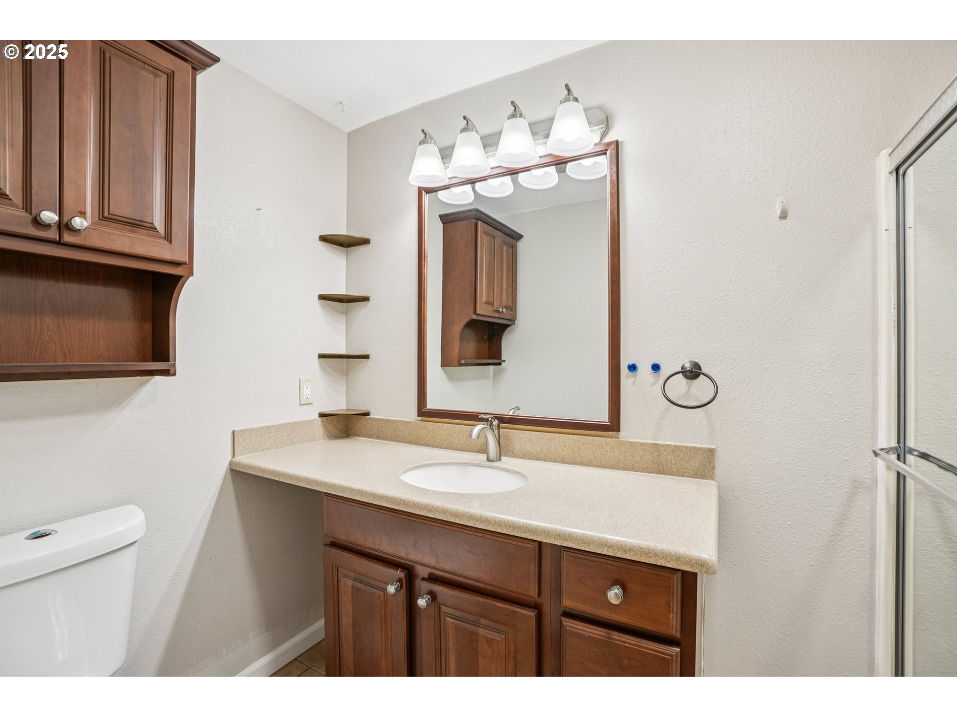 9281 Southwest Boones Ferry Road Portland, OR 97219 - Photo 11 of 27 a bathroom with a sink vanity and a mirror