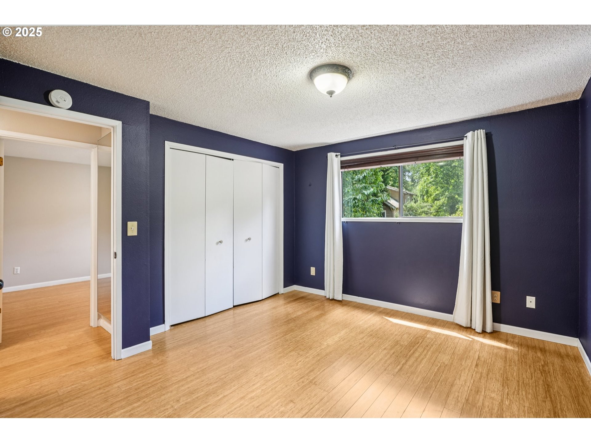 9281 Southwest Boones Ferry Road Portland, OR 97219 - Photo 13 of 27 a view of an empty room with wooden floor and a window