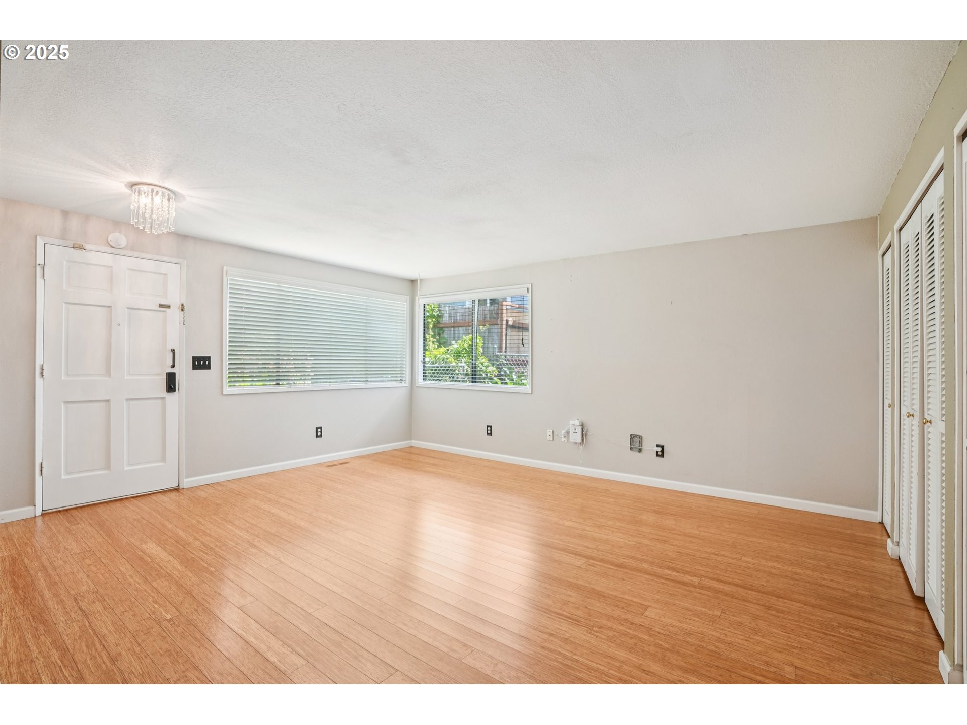 9281 Southwest Boones Ferry Road Portland, OR 97219 - Photo 4 of 27 a view of an empty room with wooden floor and a window