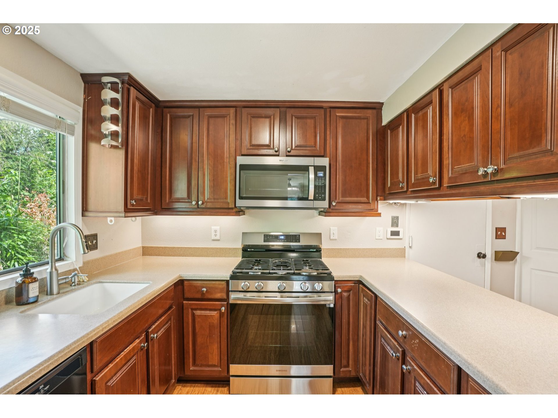 9281 Southwest Boones Ferry Road Portland, OR 97219 - Photo 6 of 27 a kitchen with a sink stove and microwave