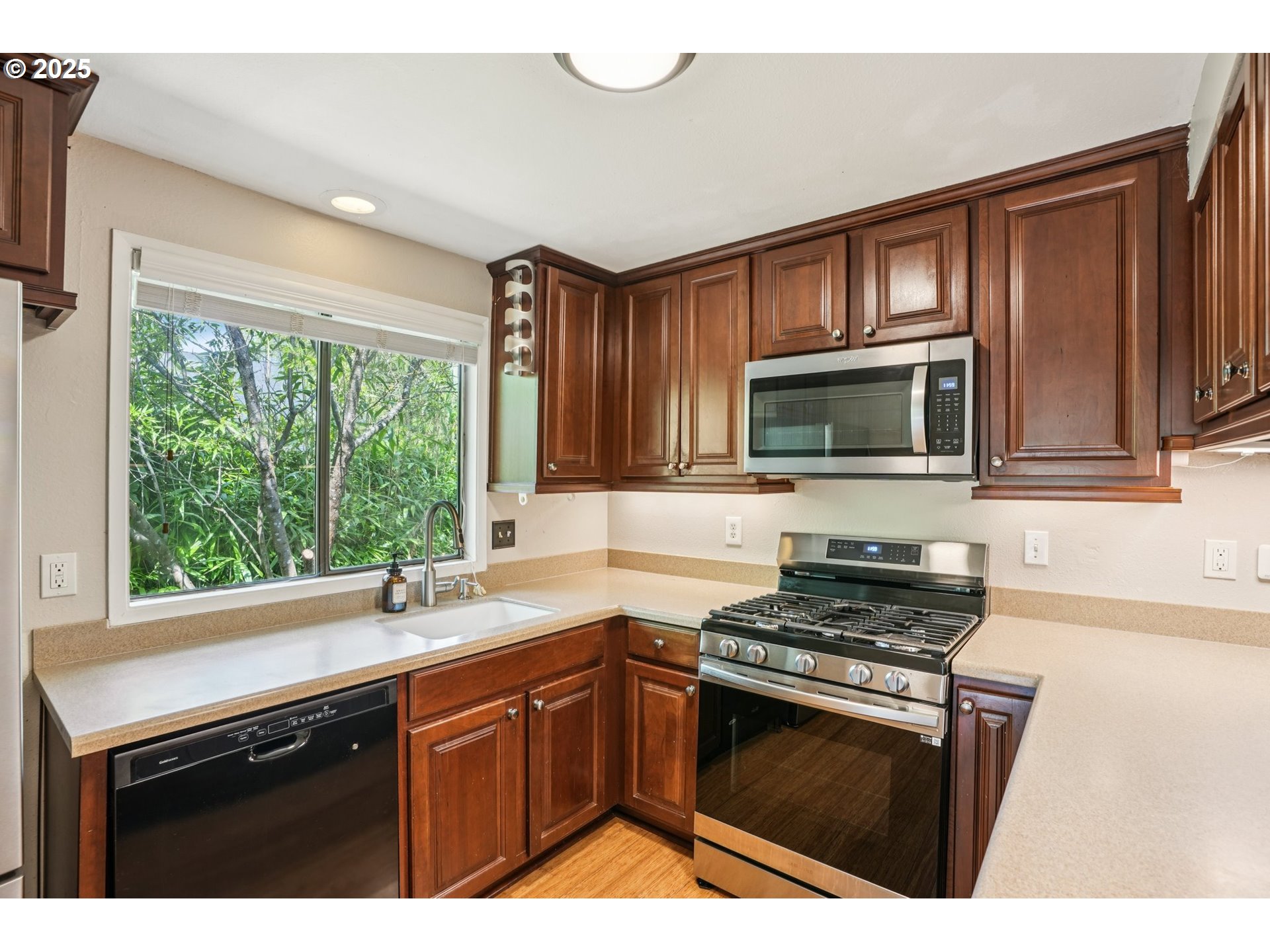 9281 Southwest Boones Ferry Road Portland, OR 97219 - Photo 7 of 27 a kitchen with granite countertop a stove sink and microwave