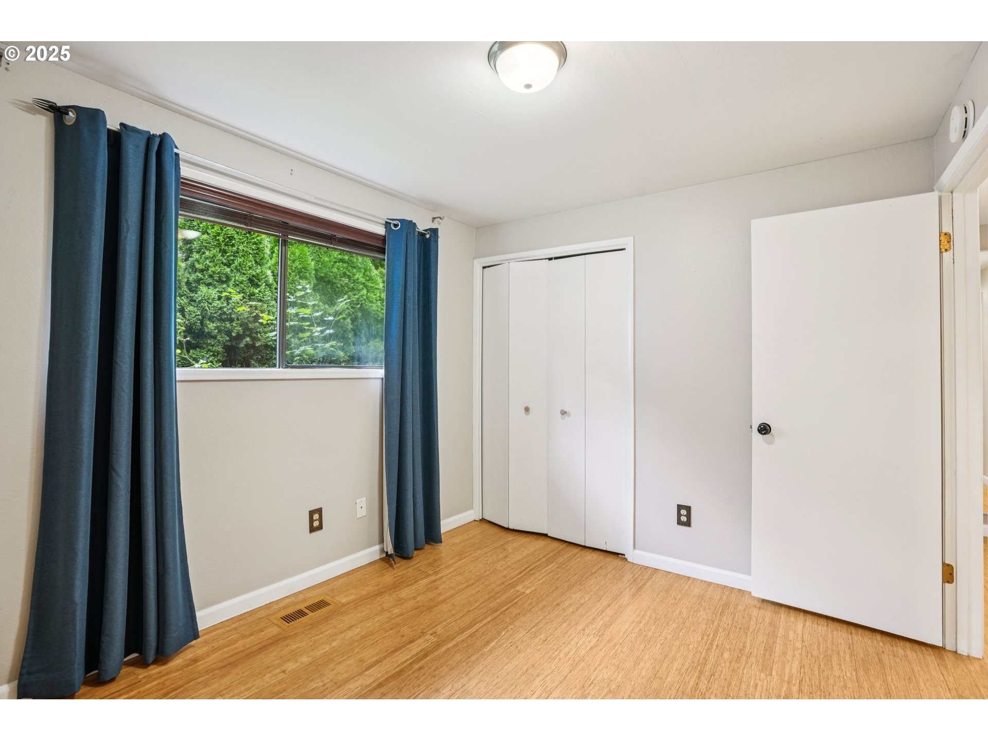 9281 Southwest Boones Ferry Road Portland, OR 97219 - Photo 10 of 27 a view of an empty room with wooden floor and a window
