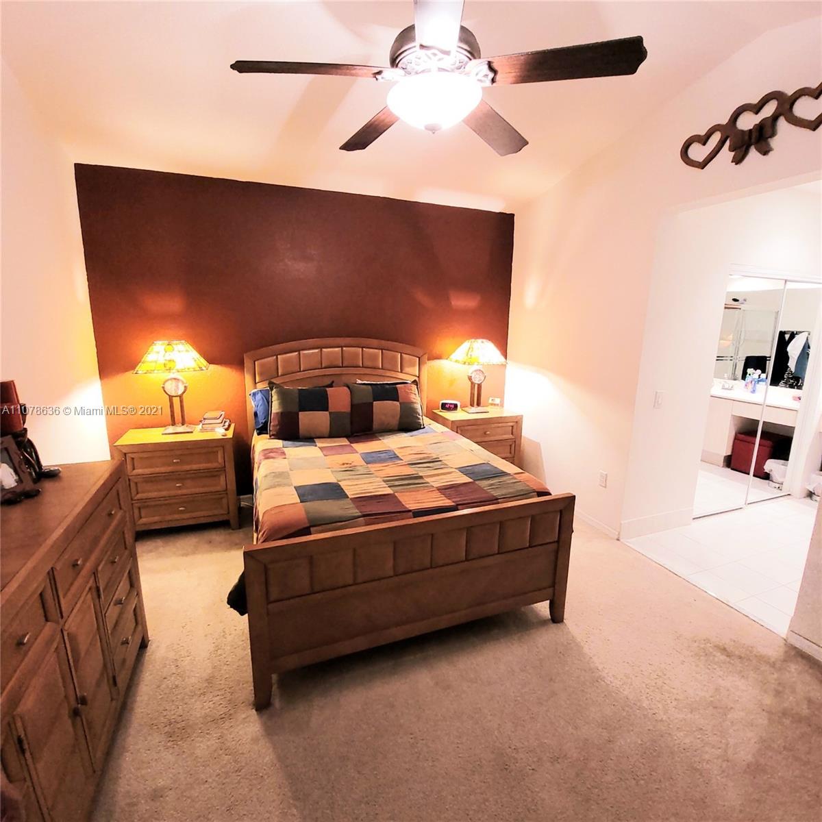 Keys Gate Homestead, FL 33035 - Photo 19 of 26 a bedroom with a bed and a chandelier