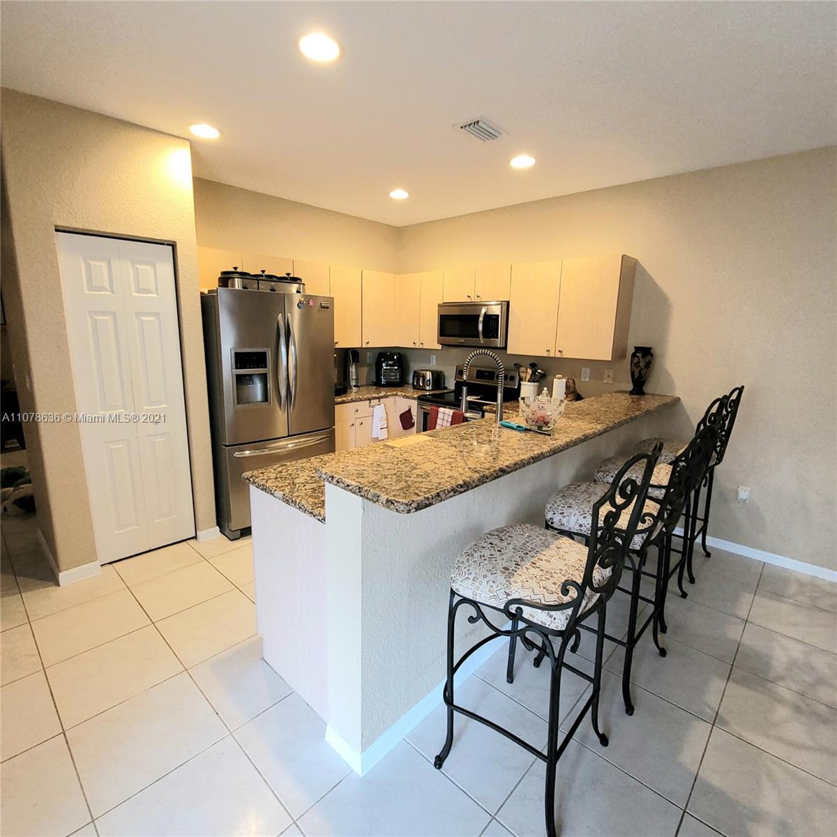 Keys Gate Homestead, FL 33035 - Photo 8 of 26 a kitchen with stainless steel appliances kitchen island granite countertop a table and chairs in it