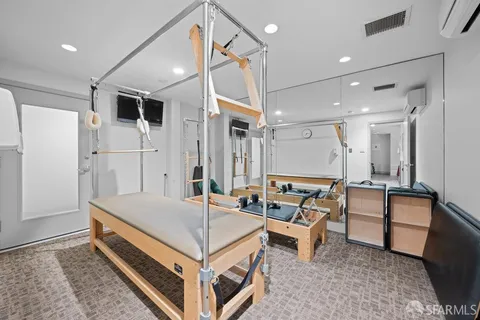 a room with gym equipment and wooden floor