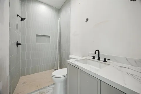 a bathroom with a sink a toilet and shower