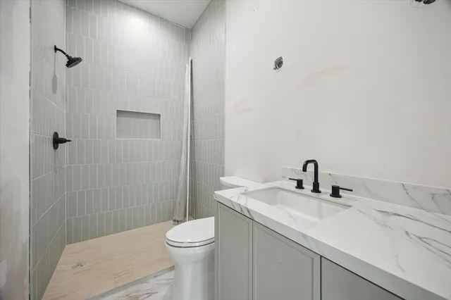 a bathroom with a sink a toilet and shower