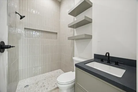 a bathroom with a sink a toilet and shower