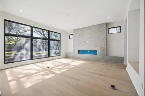 a view of an empty room with a window and a kitchen