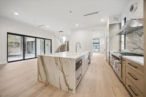 a kitchen with sink a stove and wooden floors