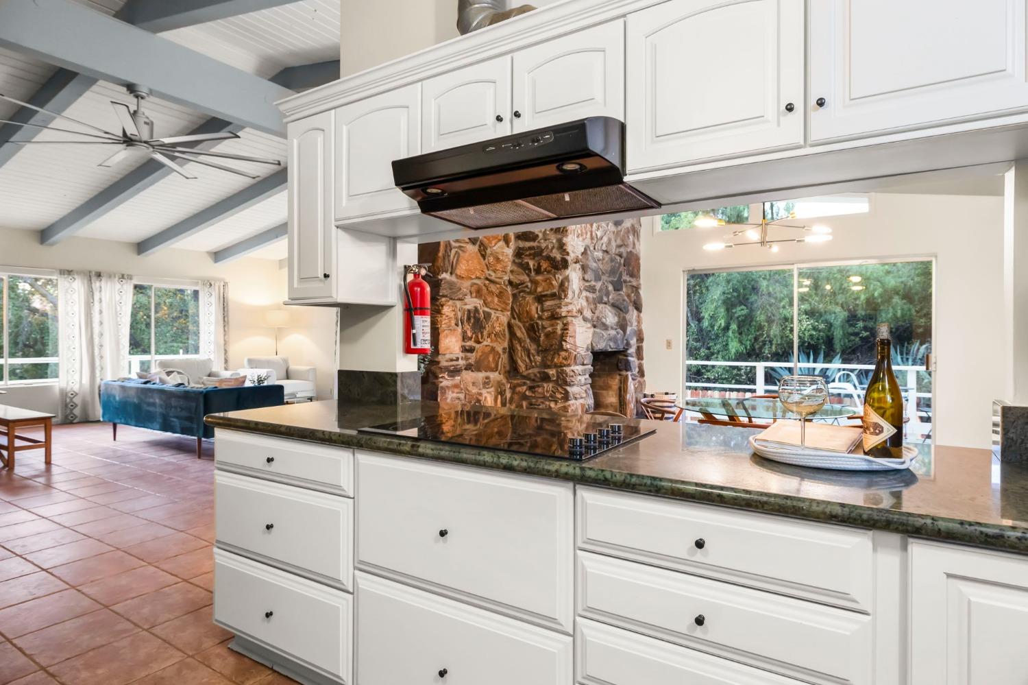 4306 Hendrickson Road Ojai, CA 93023 - Photo 25 of 44 a kitchen with granite countertop white cabinets and white appliances