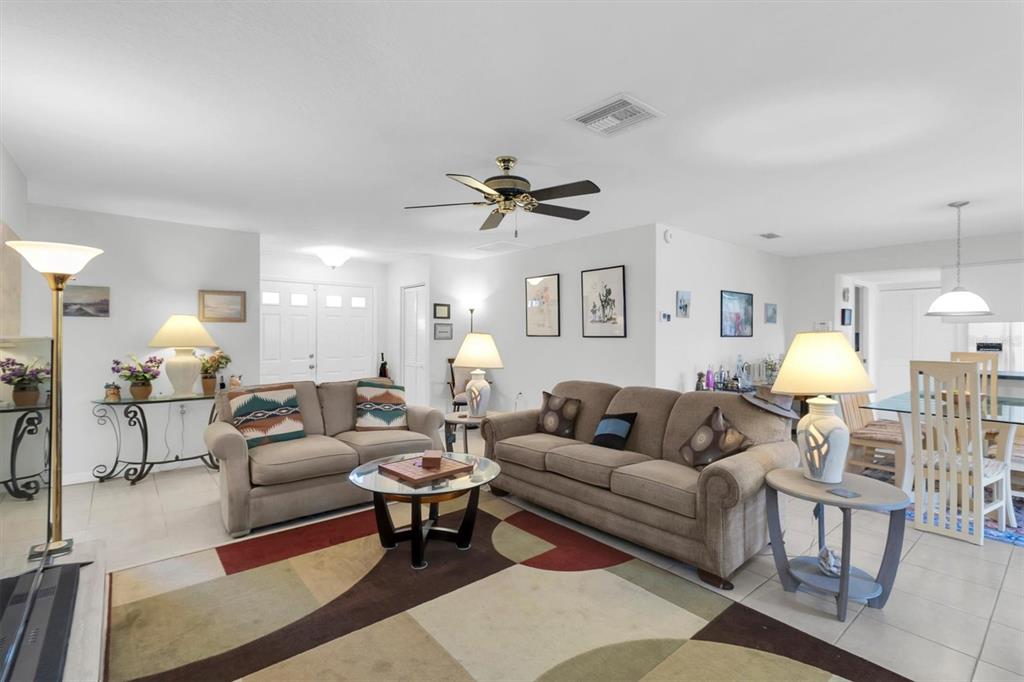 9052 Arundle Place New Port Richey, FL 34655 - Photo 7 of 57 a living room with furniture a rug and a chandelier
