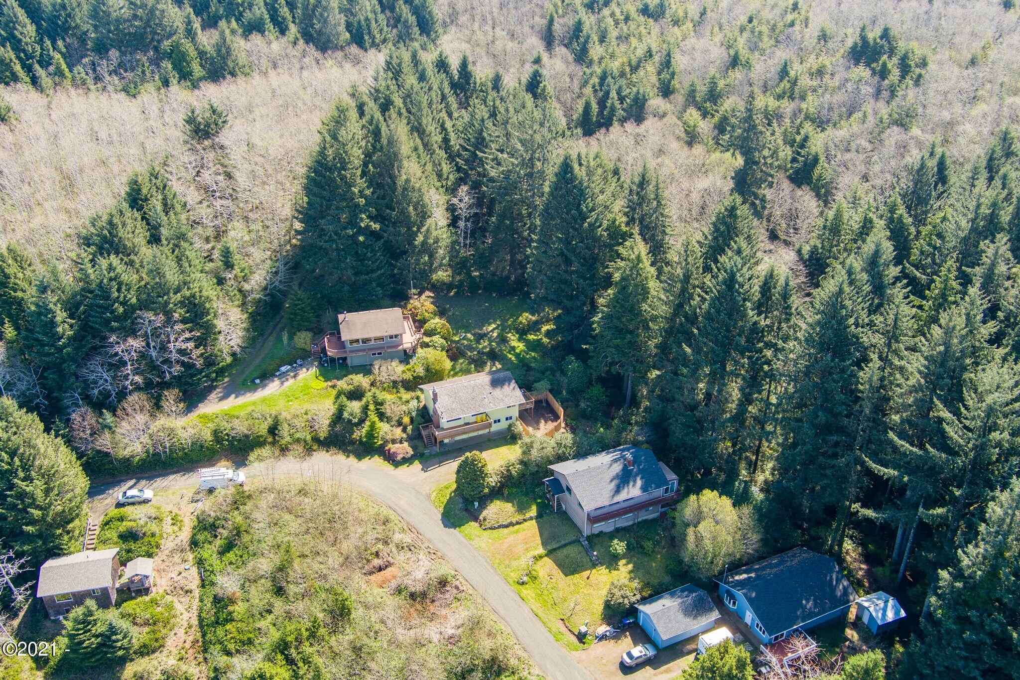 3048 Northeast East Line Road Yachats, OR 97498 - Photo 28 of 31 a view of a swimming pool with some plants and large trees