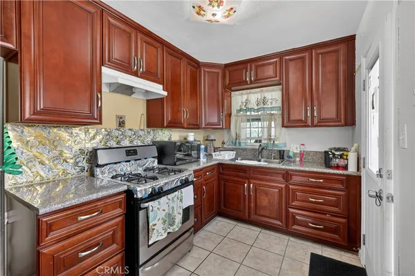 a kitchen with stainless steel appliances granite countertop wooden cabinets a stove a sink and dishwasher