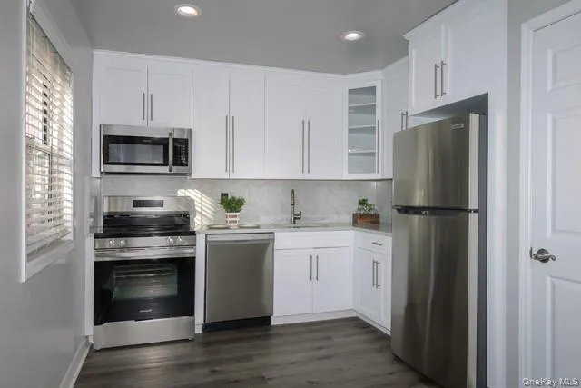 a kitchen with white cabinets and stainless steel appliances