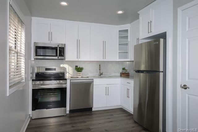 70 Middleton Road, Unit SF06 Bohemia, NY 11716 - Photo 2 of 11 a kitchen with white cabinets and stainless steel appliances