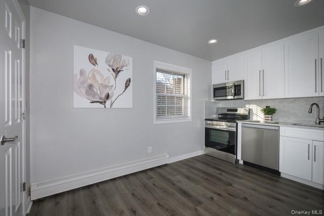 70 Middleton Road, Unit SF06 Bohemia, NY 11716 - Photo 3 of 11 a kitchen with granite countertop white cabinets and black appliances