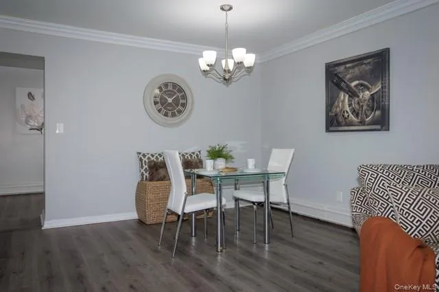 a dining room with wooden floor a chandelier a wooden table and chairs