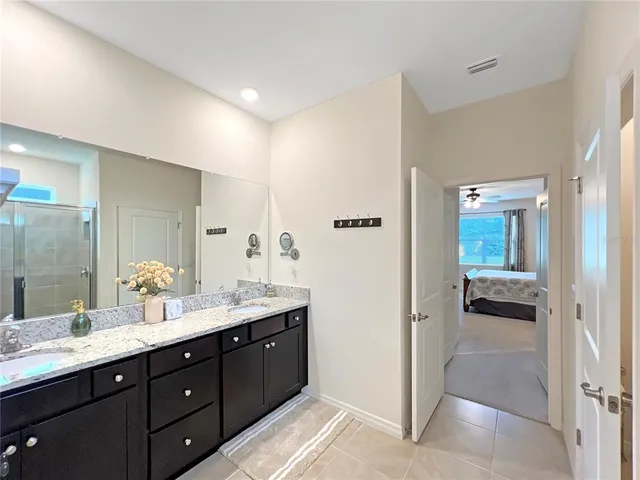 a spacious bathroom with a double vanity sink and mirror