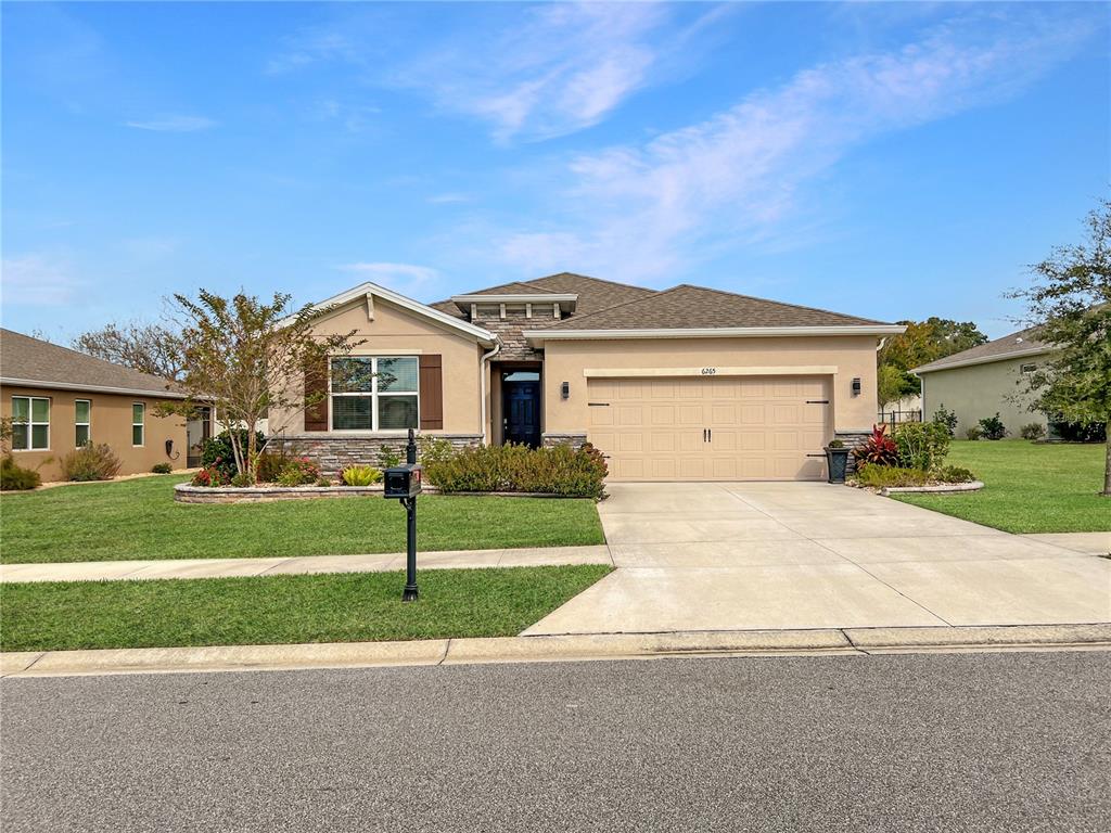 6265 Southwest 88th Loop Ocala, FL 34476 - Photo 15 of 42 a front view of a house with a yard and garage