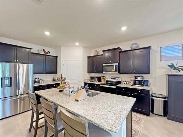 a kitchen with kitchen island a sink stove and refrigerator