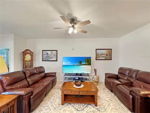a living room with furniture ceiling fan and a rug