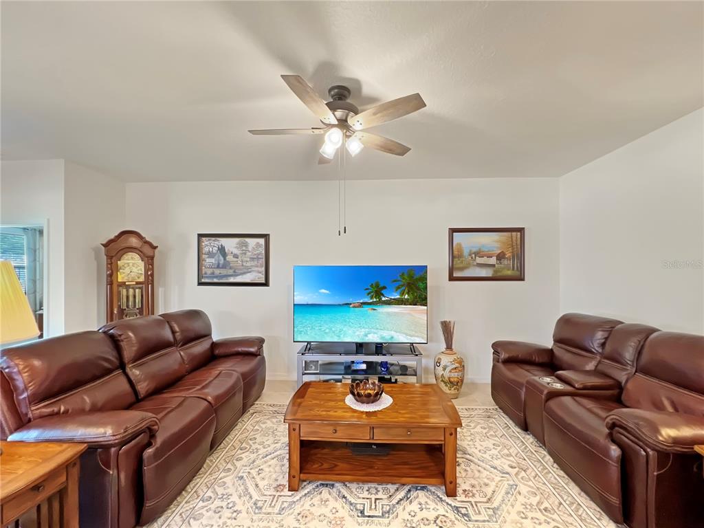 6265 Southwest 88th Loop Ocala, FL 34476 - Photo 22 of 42 a living room with furniture ceiling fan and a rug