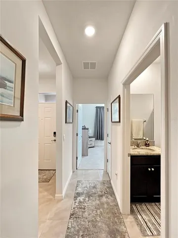 a view of a hallway with bathroom and mirror