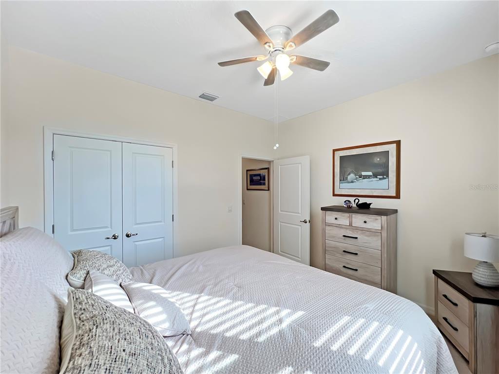6265 Southwest 88th Loop Ocala, FL 34476 - Photo 26 of 42 a bedroom with a bed and a chandelier