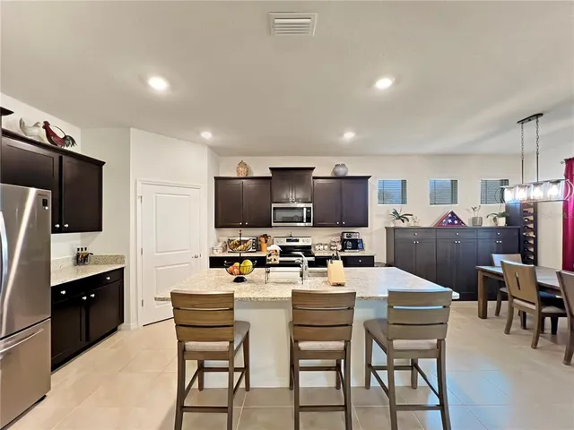 a kitchen with a table chairs refrigerator and a microwave