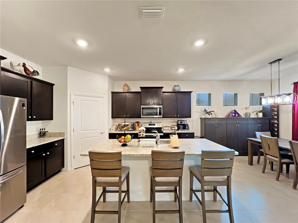 6265 Southwest 88th Loop Ocala, FL 34476 - Photo 28 of 42 a kitchen with a table chairs refrigerator and a microwave
