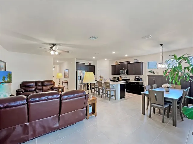 a living room with furniture kitchen view and a potted plant