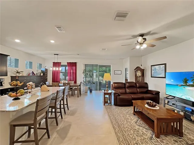 a living room with furniture kitchen view and a window